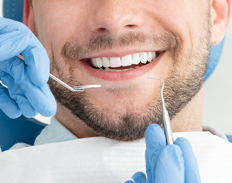 Young man at the dentist. Dental care, taking care of teeth. Picture with copy space for background.